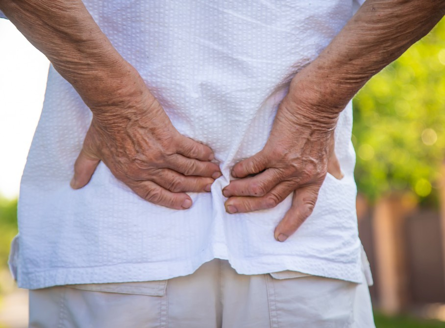 Image of an older woman holding her lower back