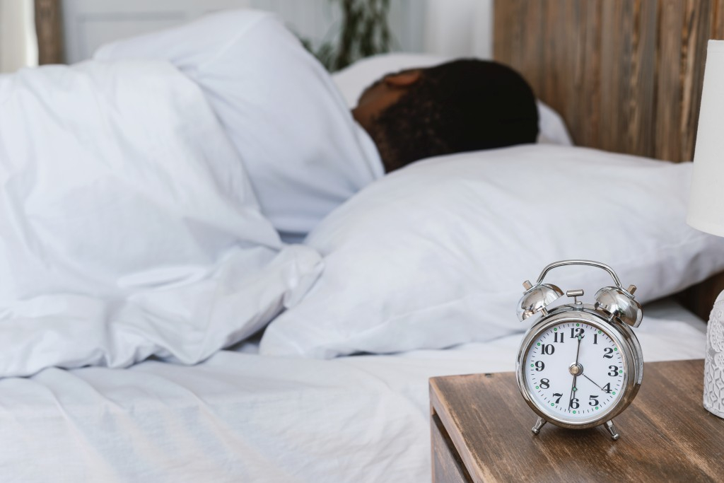 Image showing a man sleeping through his alarm clock