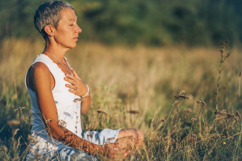 Older Woman Practicing Mindfulness Meditation in an open field